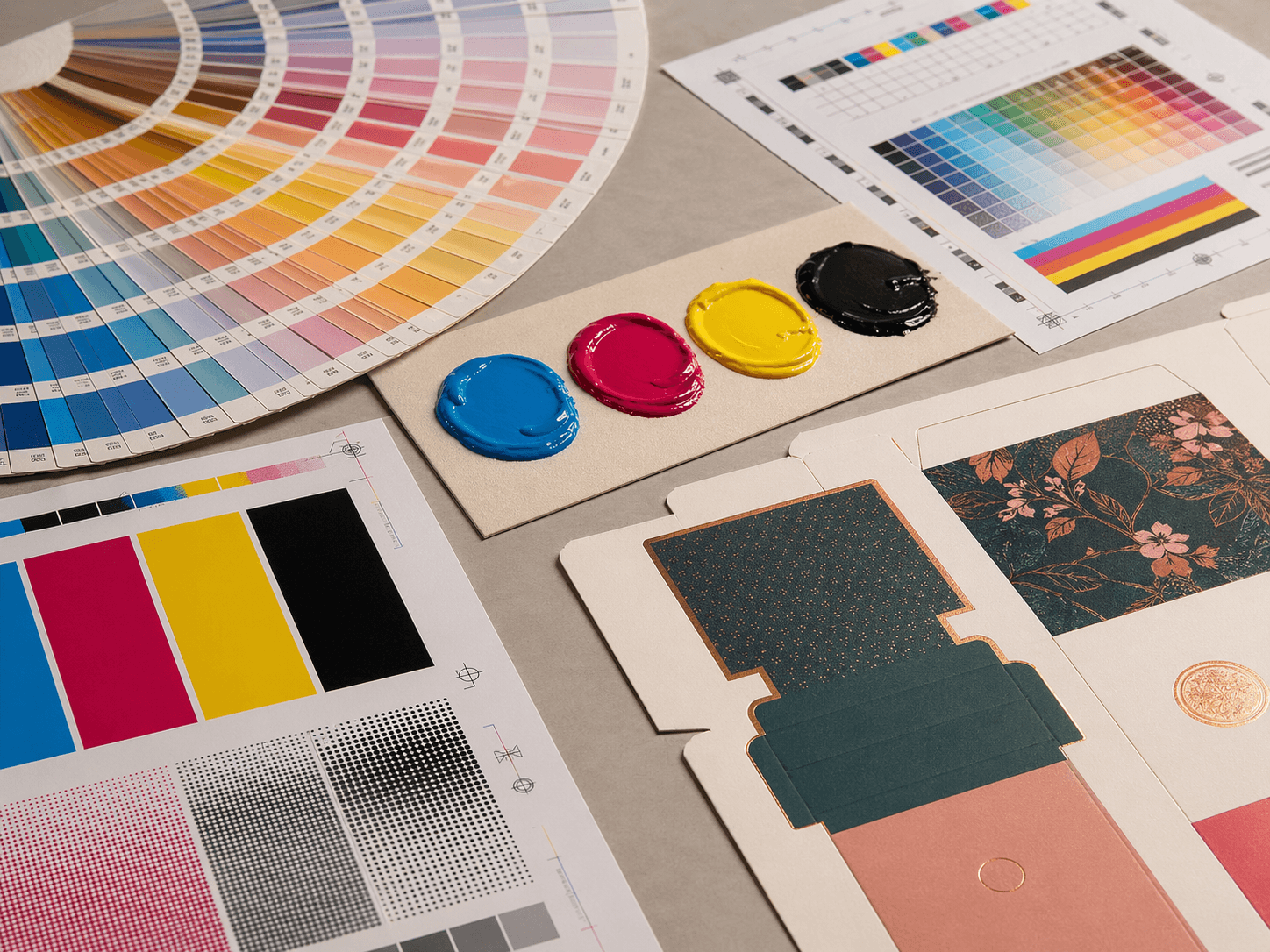 CMYK inks, Pantone colour swatches and printed paperboard packaging samples showing colour control for custom packaging.
